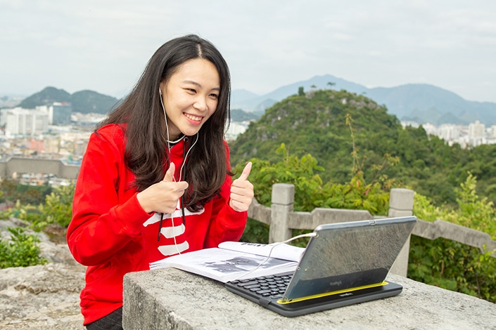 a CLI teacher giving a double thumbs up to an online student