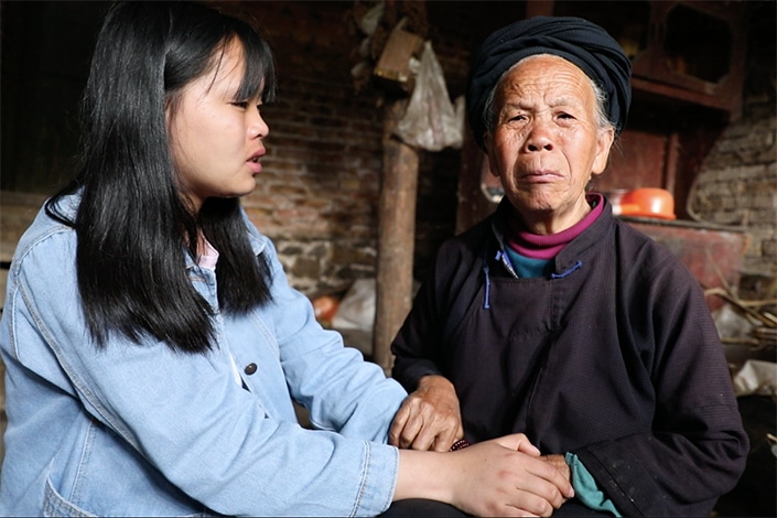 An Chinese old lady is talking to her grand daughter