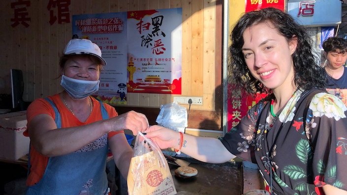 a CLI student buying snacks from a street vendor