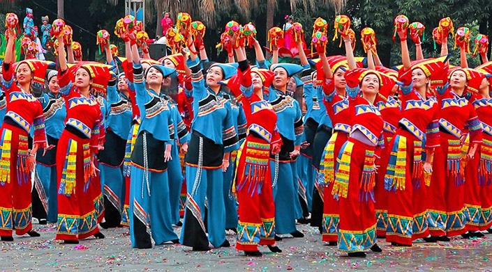 a group of Zhuang women dance with embroidered balls. 
