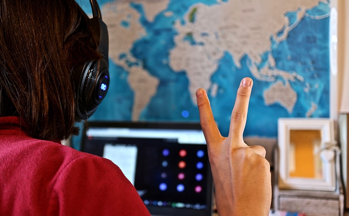 a teacher making a victory sign while helping students learn Chinese on Zoom