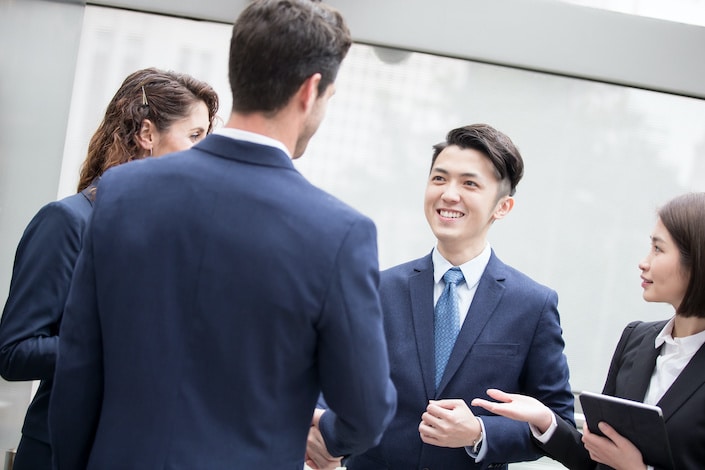 a group of two men and two women in suits smiling at each other