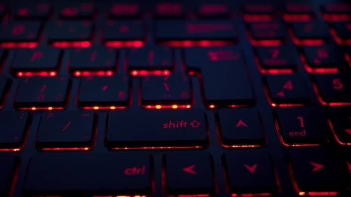 section of the keys on a computer keyboard which appear black with orange-red lights shining underneath